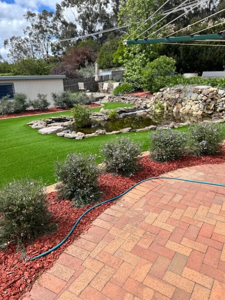 Backyard beds freshly mulched around lawn and pond