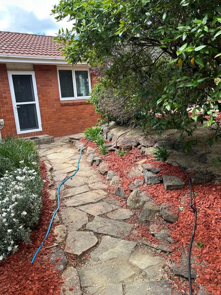 Clear stone path with fresh red mulch after